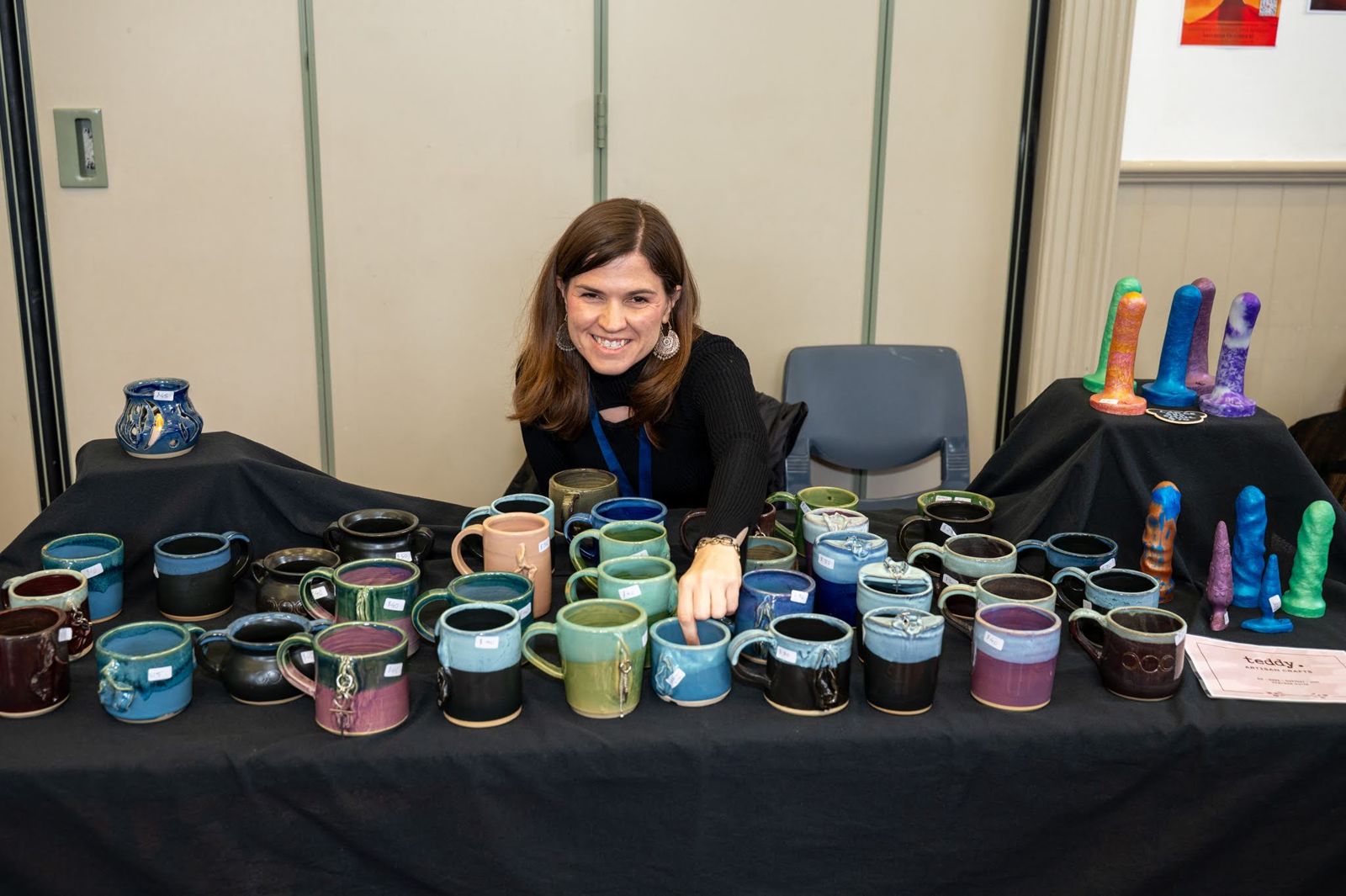 A ceramicist smiling behind her stall